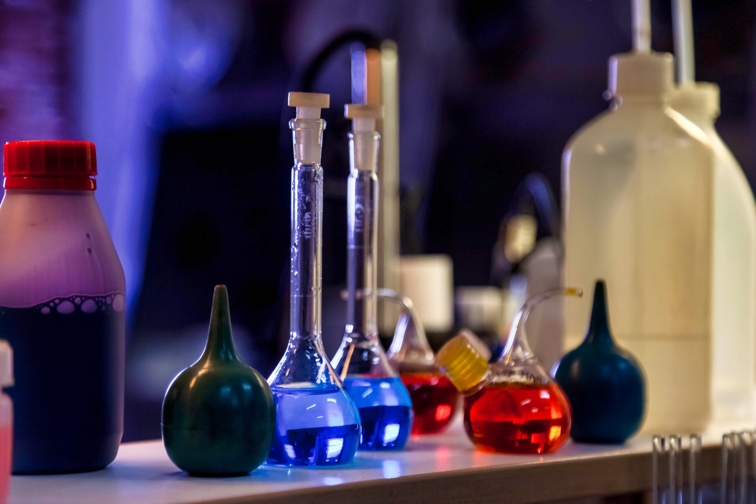 Close up of flasks and test tubes with acid in chemical laboratory. Reagents acid suspensions for experiments. Conical flask with samples of acids. Chemical industry concept. Copy ad text space